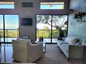 sala de estar con 2 sofás y TV en Azulita Oasis, en Aguas Zarcas