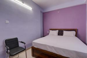 una piccola camera con letto e sedia di Super OYO The Suncity Hotel a Patna