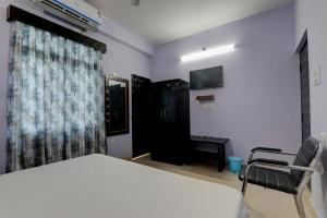 una camera con un letto e una sedia e una finestra di Super OYO The Suncity Hotel a Patna