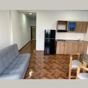sala de estar con sofá y nevera en Apartamentos Amoblados Napoles en Doradal