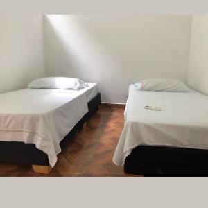 dos camas sentadas una al lado de la otra en una habitación en Apartamentos Amoblados Napoles en Doradal