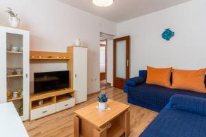 a living room with a blue couch and a tv at Apartment Mici 1 - great location and relaxing in Cres