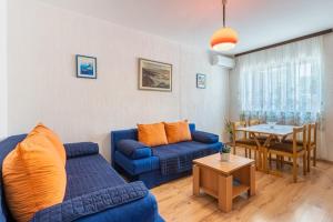 a living room with a blue couch and a table at Apartment Mici 1 - great location and relaxing in Cres