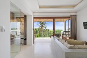 a living room with a couch and a view of the ocean at Pagi Villas by Hombali in Mengwi