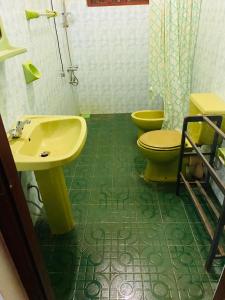 a bathroom with a yellow sink and two toilets at Green nature villa in Hapugala