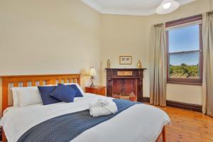 a bedroom with a bed with a teddy bear on it at Barossa Vineyard Guesthouse in Tanunda