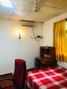 Habitación con cama, escritorio y cortina amarilla. en Green nature villa en Hapugala