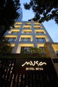 una señal de hotel frente a un edificio alto en Hotel Mvsa+Michelin 2 Starred Molino de Urdàniz, en Taipéi