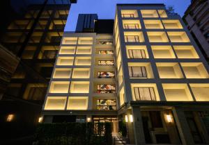 a tall building with many windows at night at Hotel Mvsa+Michelin 2 Starred Molino de Urdàniz in Taipei