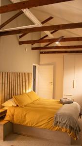a bedroom with a large yellow bed in it at Leipoldt Self-Catering Apartment in Secunda