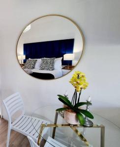 een kamer met een spiegel en een glazen tafel met een stoel bij Cottage at 6 on Elba in Paarl