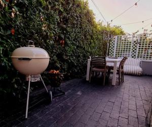 a grill sitting on a patio with a table and chairs at Cottage at 6 on Elba in Paarl
