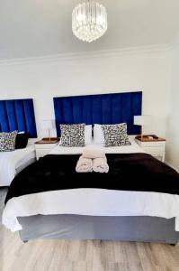 a bedroom with a large bed with blue curtains at Cottage at 6 on Elba in Paarl