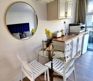 een keuken met een spiegel en een tafel en stoelen bij Cottage at 6 on Elba in Paarl
