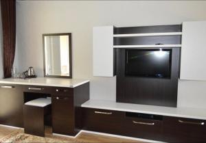 een kamer met een televisie en een bureau met een spiegel bij Cozy Family Cottages in Vǝndam