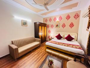 a hotel room with a bed and a couch at Paras Inn in New Delhi