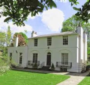 a large white house with a green lawn at Cosy and functional Studio in London in Colindale