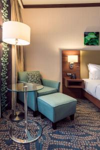 a hotel room with a bed and a chair and a table at Hilton Garden Inn Astana in Astana +33 photos