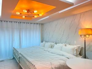 1 cama blanca grande en una habitación con techo en Home Theater 209 en Suncheon