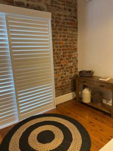 a room with a door and a rug and a brick wall at MURRUMBURRAH ARTHOUSE APARTMENTS in Harden