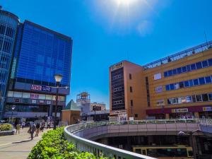 una ciudad con edificios y gente caminando por una calle en APA Hotel Sagamihara Hashimoto Ekimae en Sagamihara