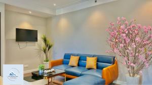 a living room with a blue couch and a tv at Bluewaves Apartment Quy Nhon in Quy Nhon