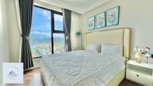 sypialnia z dużym łóżkiem i dużym oknem w obiekcie Bluewaves Apartment Quy Nhon w mieście Quy Nhơn