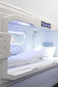 una cama de hospital vacía en una habitación de hospital en NapTapGo - Japanese Premium POD Hotel - Walk to Noida Electronic City Metro! Wifi, Lounge, en Noida