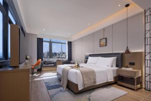 a bedroom with a large white bed and a large window at Shenzhen Zhongchen International Hotel - Shenzhen Baolong Subway Station Branch in Shenzhen