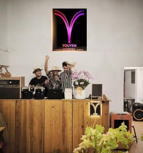 a group of three men standing behind a counter at Youyen Hostel in Ban Don Muang (1)