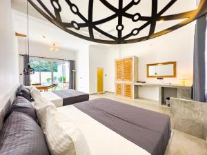 a bedroom with two beds and a large chandelier at Moringa Mirissa in Mirissa