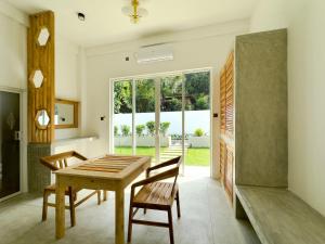 una sala da pranzo con tavolo, sedie e finestra di Moringa Mirissa a Mirissa
