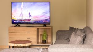ein Wohnzimmer mit einem Sofa und einem Flachbild-TV in der Unterkunft Leipoldt Self-Catering Apartment in Secunda