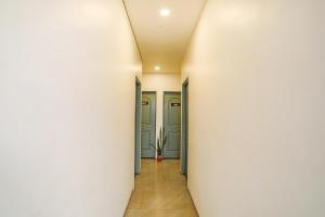 a corridor of a hallway with doors and a plant at FabExpress Pramila Prakash in Nagpur