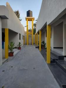 a hallway of a building with yellow pillars and plants at LES 9 Plurielles T3 KPALIME KOUMA KONDA in Palimé