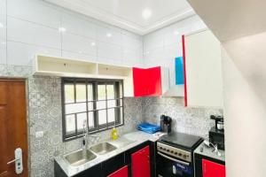 a kitchen with two sinks and red cabinets at LES 9 Plurielles T3 KPALIME KOUMA KONDA in Palimé