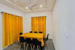 LES 9 Plurielles T3 KPALIME KOUMA KONDA في Kpalimé: قاعة اجتماعات مع طاولة مع كراسي وستائر صفراء