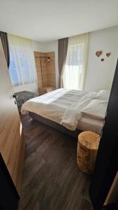 a bedroom with a large bed and a wooden floor at Casa Il Giardino in Pozza di Fassa