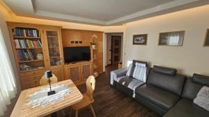 a living room with a couch and a table at Casa Il Giardino in Pozza di Fassa