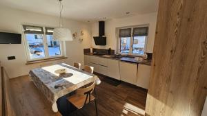 a kitchen with a wooden table and a table and chairs at Casa Il Giardino in Pozza di Fassa