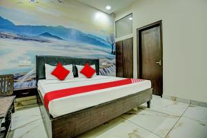 1 dormitorio con 1 cama con una pintura en la pared en OYO Flagship Hotel Sangam Palace, en Bamrauli