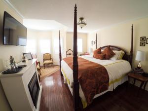 ein Schlafzimmer mit einem großen Bett und einem TV in der Unterkunft Blue Skies Bed & Breakfast in Niagara on the Lake