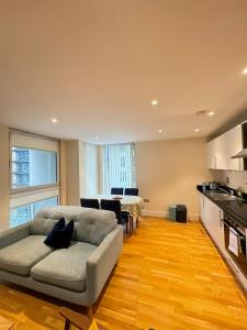 a living room with a couch and a table at Contemporary 2BD Flat wBalcony Canary Wharf! in London