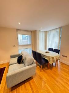 a living room with a couch and a table at Contemporary 2BD Flat wBalcony Canary Wharf! in London
