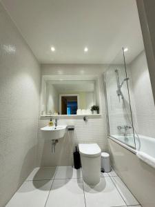 a bathroom with a toilet and a sink at Contemporary 2BD Flat wBalcony Canary Wharf! in London