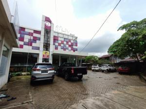 un estacionamiento con autos estacionados frente a un edificio en Urbanview Hotel B Liv Kendari, en Puunggolaka