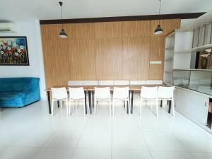 Puunggolaka的住宿－Urbanview Hotel B Liv Kendari，一间带桌子和白色椅子的用餐室