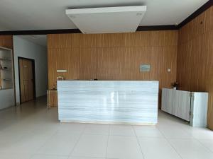 a large white counter in a room with wooden walls at Urbanview Hotel B Liv Kendari in Puunggolaka