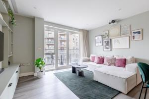 salon z białą kanapą i różowymi poduszkami w obiekcie Elegant & Serene 2BD Flat wRoof Terrace Hoxton! w Londynie