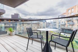 balkon z 2 krzesłami i stołem w budynku w obiekcie Elegant & Serene 2BD Flat wRoof Terrace Hoxton! w Londynie